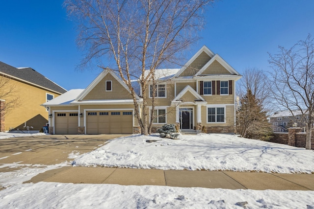 craftsman-style home with a garage, stone siding, and driveway