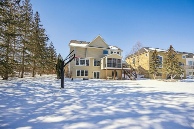 snow covered property with stairs