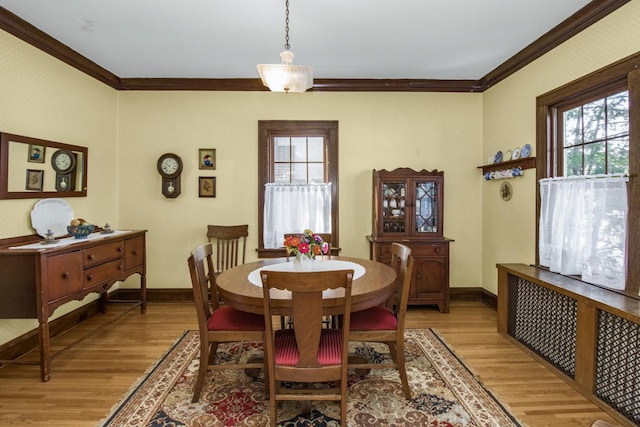 dining area with baseboards, ornamental molding, light wood-type flooring, and wallpapered walls