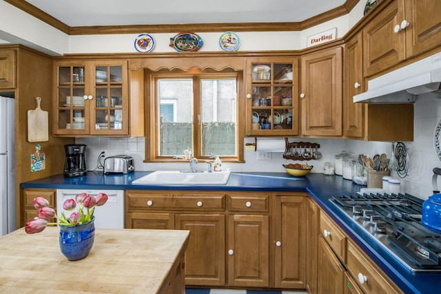 kitchen featuring stainless steel gas cooktop, brown cabinetry, dark countertops, and glass insert cabinets