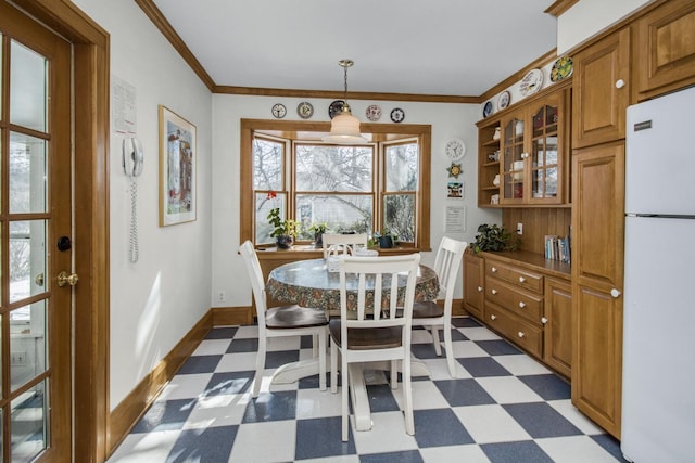 dining area with ornamental molding, dark floors, and baseboards