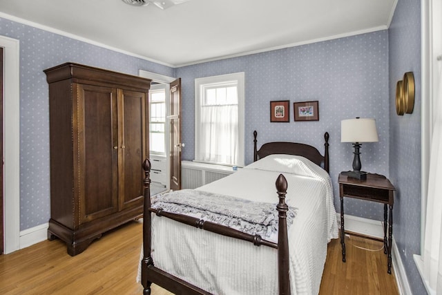 bedroom with radiator, wallpapered walls, light wood finished floors, and crown molding