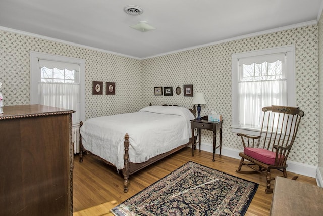 bedroom with crown molding, visible vents, and wallpapered walls