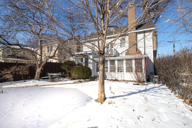 exterior space featuring a chimney and fence