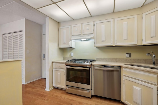 kitchen featuring white cabinets, sink, light wood-type flooring, and stainless steel appliances