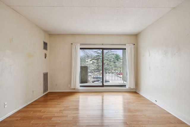 empty room featuring light hardwood / wood-style floors and a textured ceiling