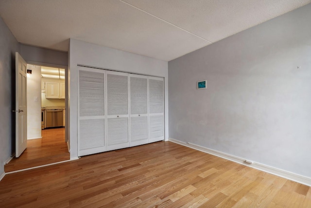 unfurnished bedroom with light wood-type flooring and a closet