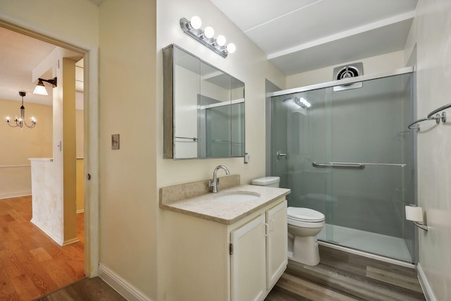 bathroom featuring an enclosed shower, vanity, wood-type flooring, a chandelier, and toilet