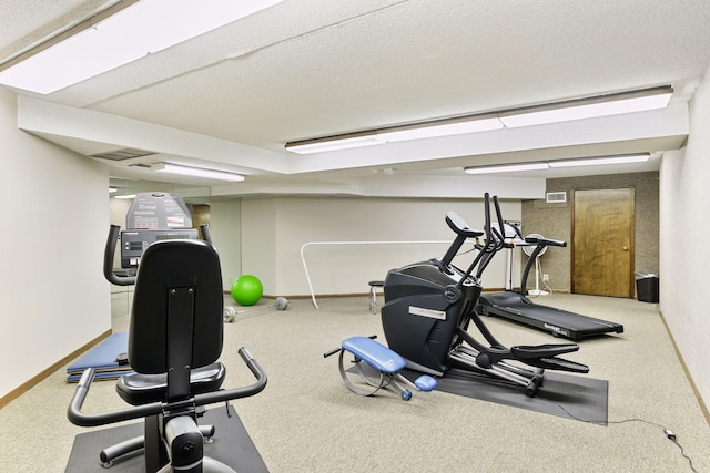 exercise room featuring carpet flooring and a textured ceiling