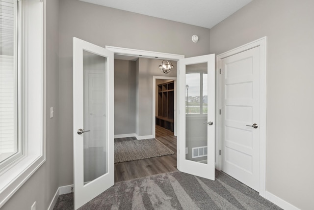 hall featuring baseboards, visible vents, and french doors