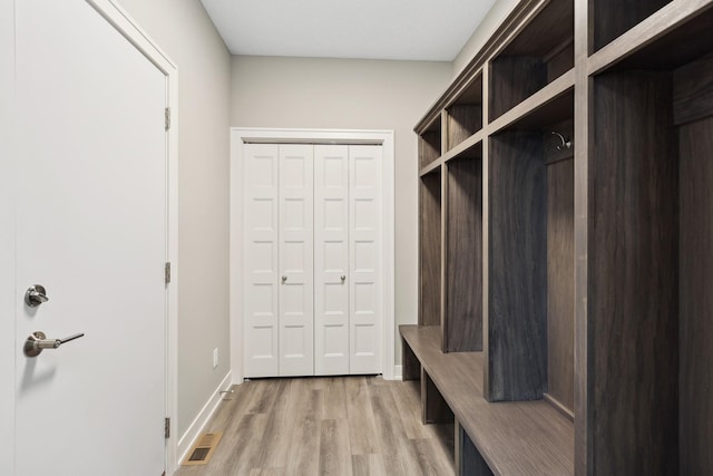 mudroom with light wood finished floors, visible vents, and baseboards