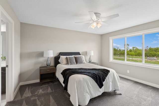 bedroom with dark colored carpet, a ceiling fan, and baseboards