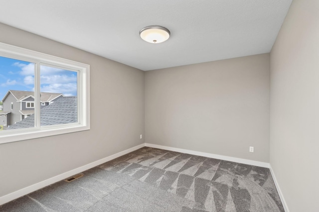 carpeted spare room with baseboards and visible vents