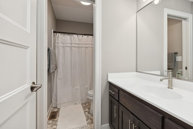 full bathroom with toilet, visible vents, and vanity