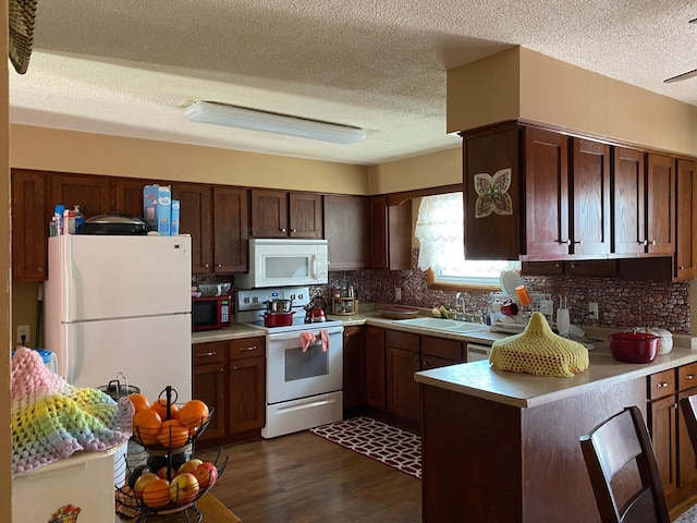 kitchen with white appliances, backsplash, dark wood-type flooring, sink, and a textured ceiling