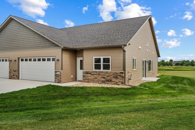 view of front facade featuring a garage, concrete driveway, a front yard, and stone siding