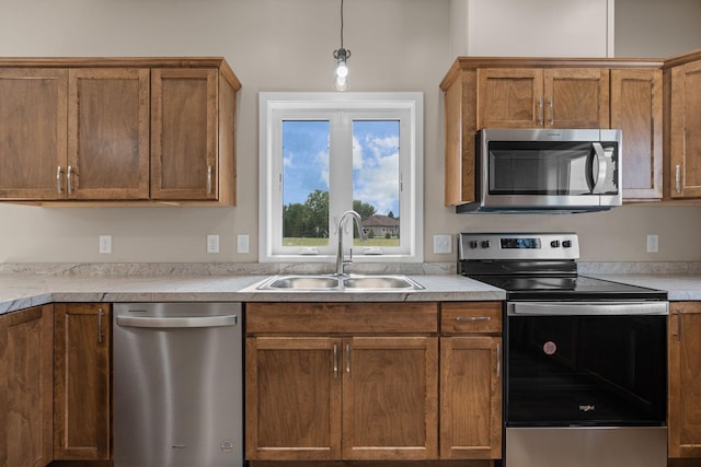 kitchen featuring a sink, light countertops, brown cabinets, and stainless steel appliances