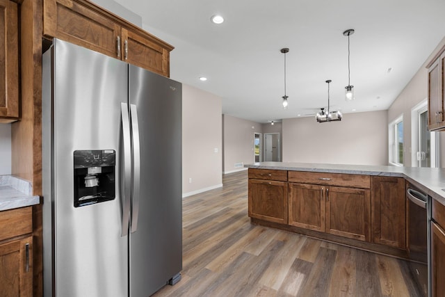 kitchen featuring light wood finished floors, pendant lighting, light countertops, recessed lighting, and stainless steel appliances