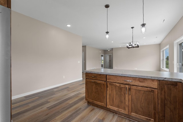 kitchen featuring hanging light fixtures, light countertops, baseboards, and wood finished floors