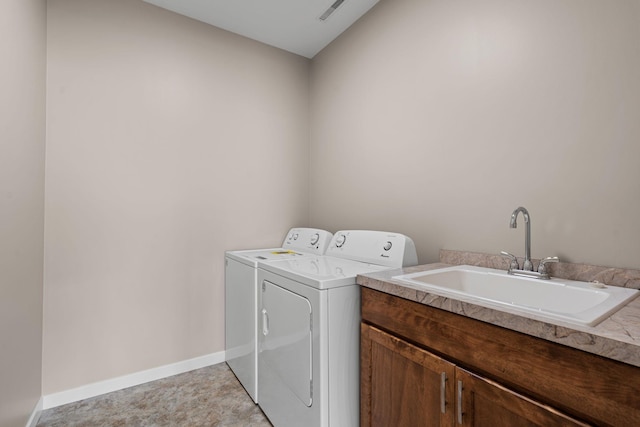 laundry area featuring washing machine and clothes dryer, visible vents, baseboards, and a sink