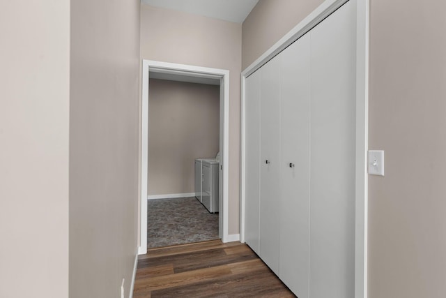 hall featuring dark wood finished floors, separate washer and dryer, and baseboards