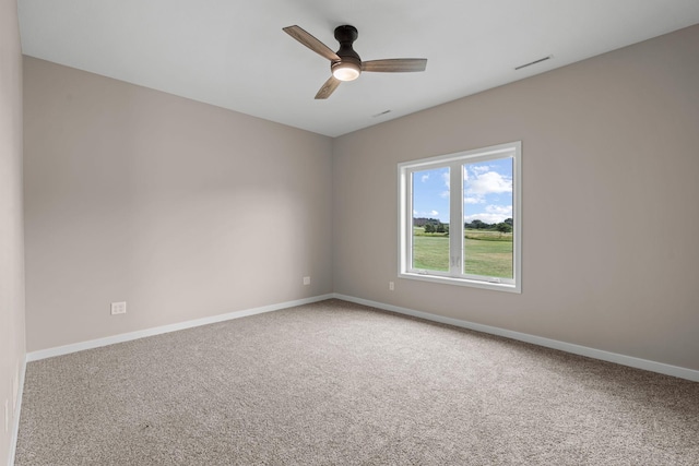 carpeted empty room with a ceiling fan and baseboards