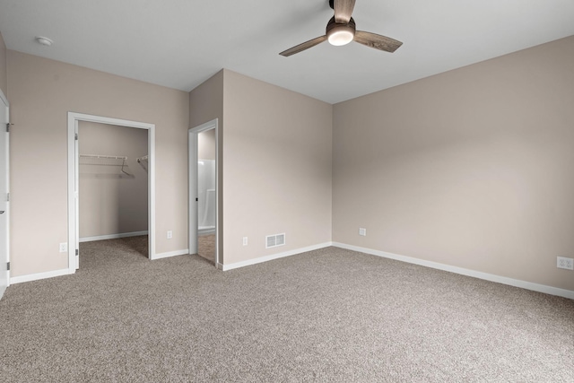 unfurnished bedroom featuring a spacious closet, carpet flooring, baseboards, and visible vents