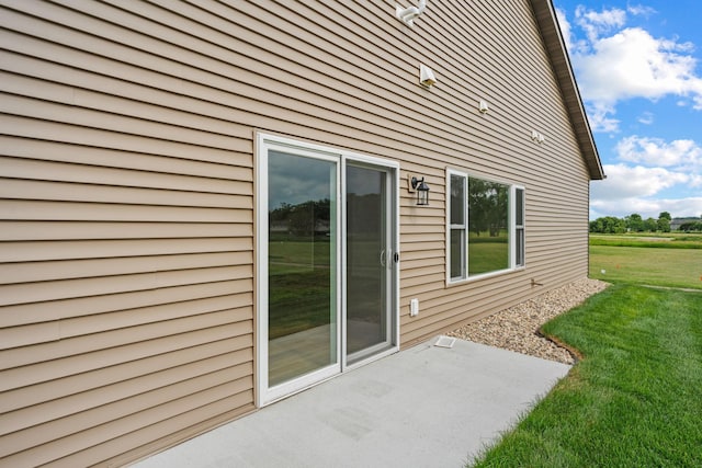 view of home's exterior with a yard and a patio