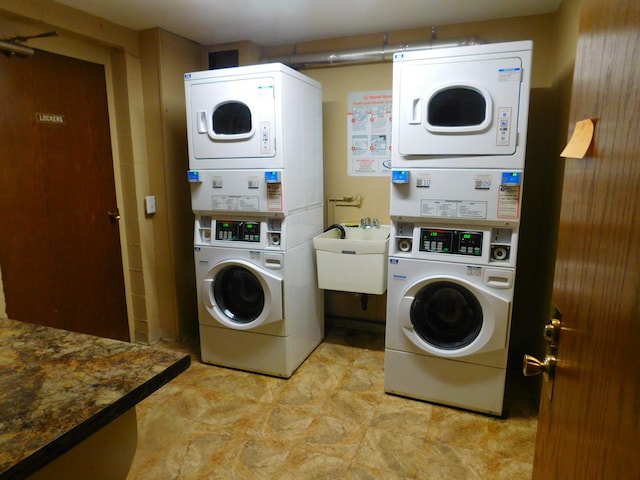 washroom featuring washing machine and dryer, stacked washing maching and dryer, and sink