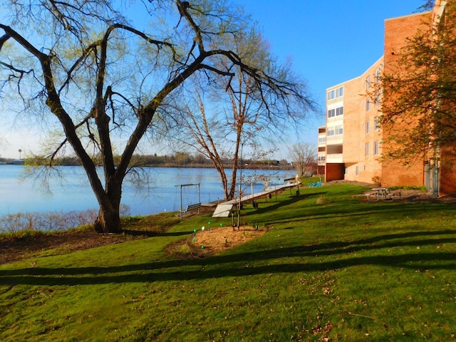 view of property's community with a yard and a water view