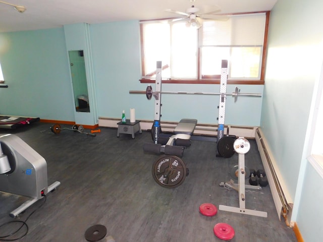 workout area featuring ceiling fan, dark wood-type flooring, and a baseboard heating unit