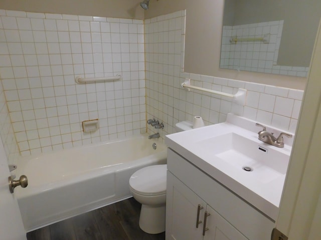 full bathroom with vanity, tile walls, hardwood / wood-style floors, toilet, and tiled shower / bath