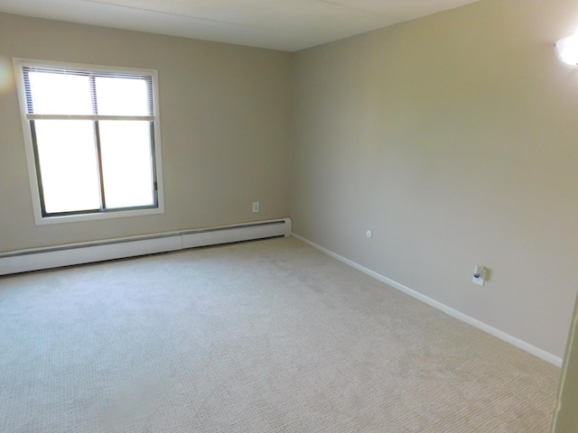 empty room featuring light carpet and a baseboard heating unit