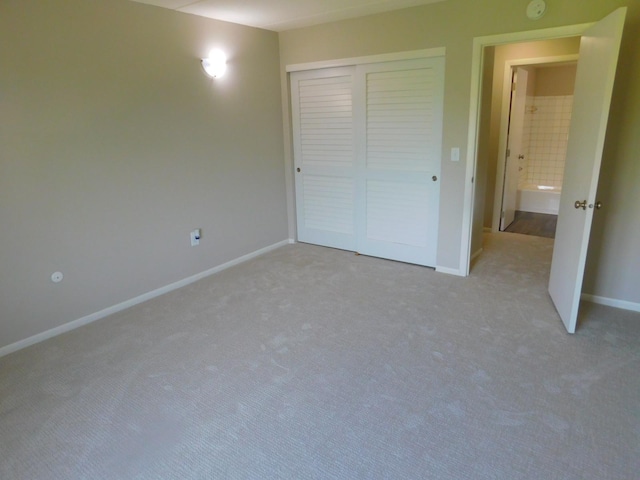 unfurnished bedroom with light carpet and a closet