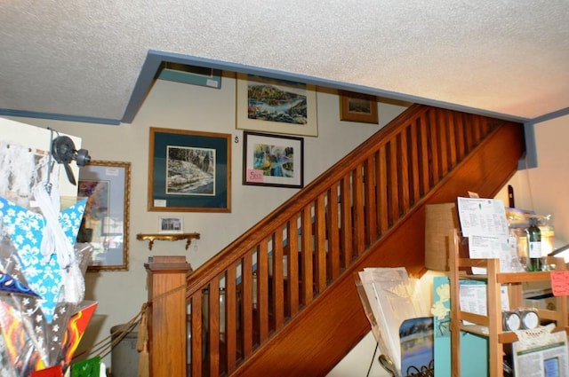 staircase featuring a textured ceiling