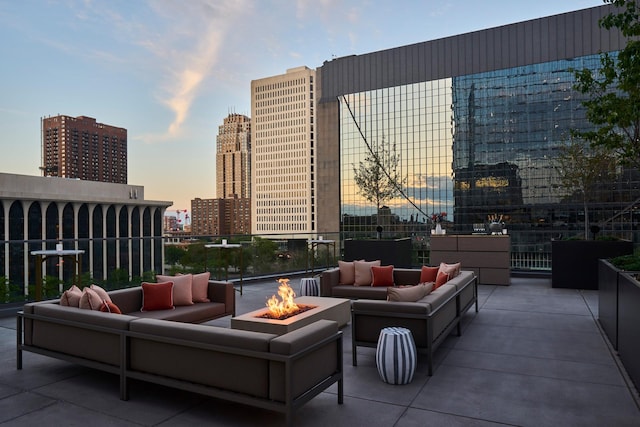 patio terrace at dusk featuring an outdoor living space with a fire pit