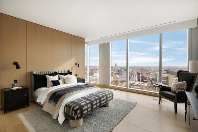 bedroom featuring light hardwood / wood-style flooring and a wall of windows