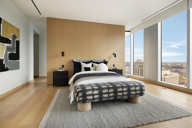 bedroom with multiple windows and light wood-type flooring