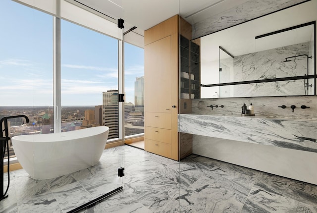 bathroom featuring a tub to relax in and floor to ceiling windows