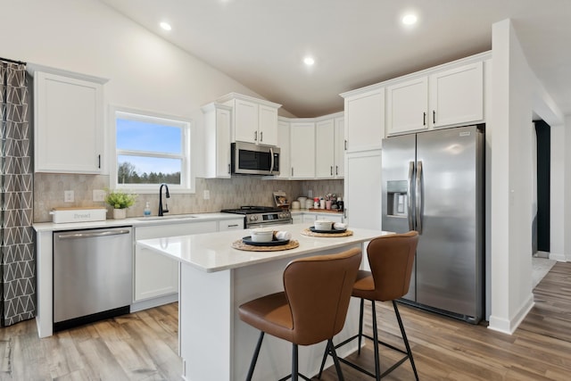 kitchen featuring appliances with stainless steel finishes, light wood-type flooring, white cabinetry, and sink