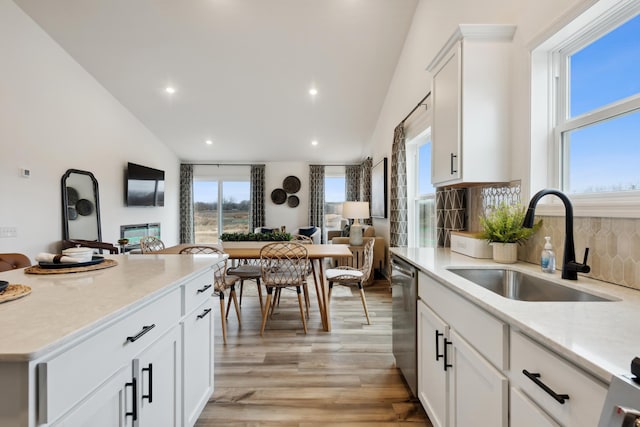 kitchen with white cabinets, lofted ceiling, and sink