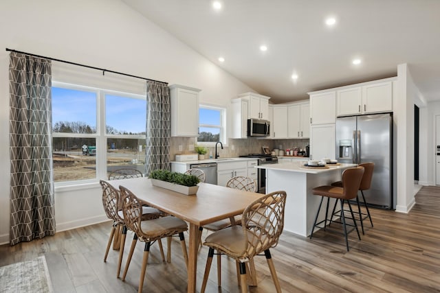 kitchen featuring a center island, sink, light hardwood / wood-style floors, white cabinetry, and appliances with stainless steel finishes