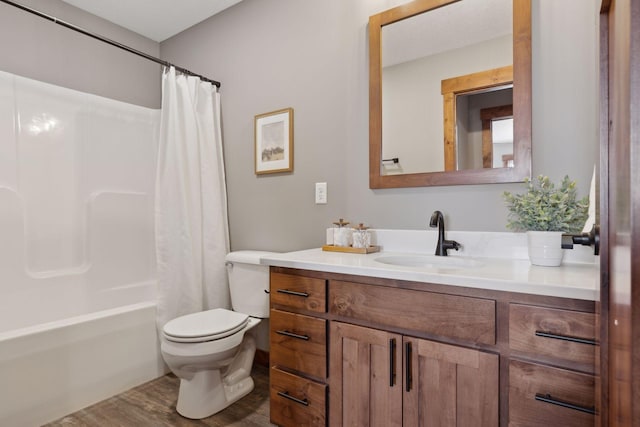 full bathroom featuring hardwood / wood-style flooring, shower / bath combo, vanity, and toilet