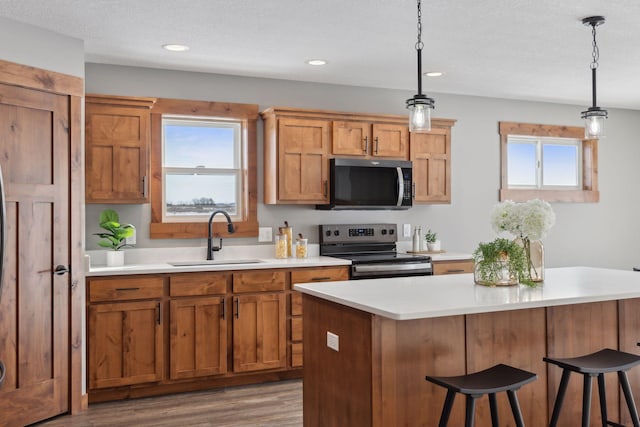 kitchen with electric stove, sink, pendant lighting, and plenty of natural light