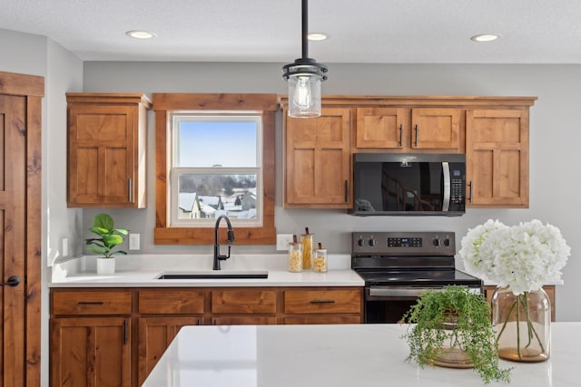 kitchen with black range with electric cooktop, decorative light fixtures, sink, and a textured ceiling