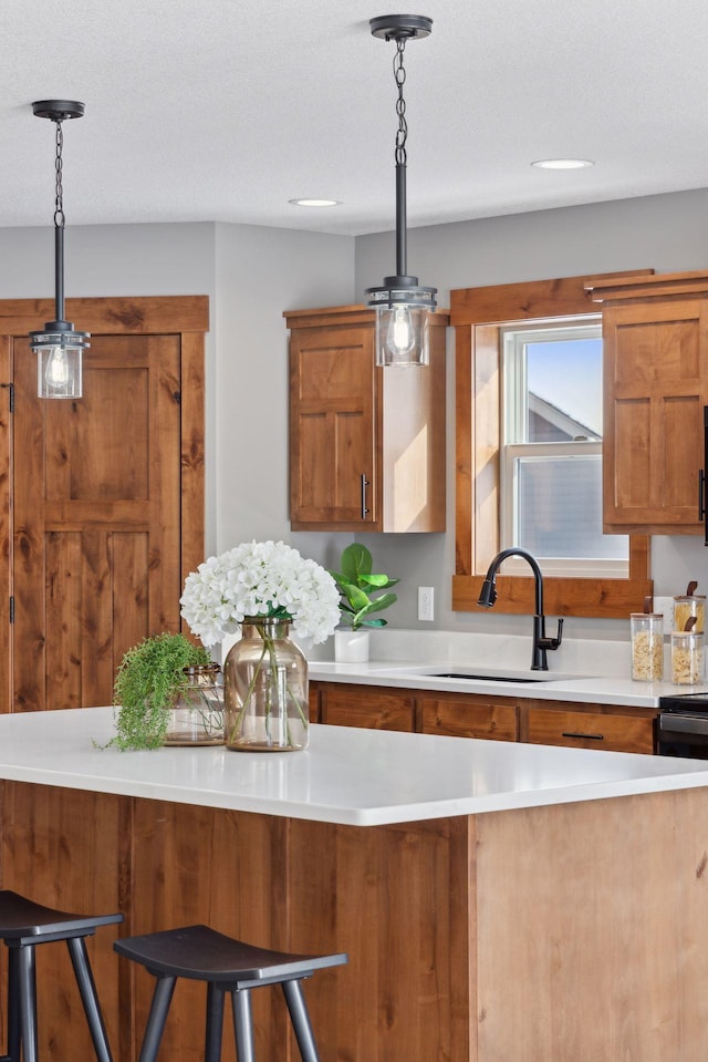 kitchen with pendant lighting, sink, and a breakfast bar area