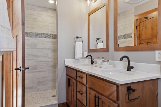 bathroom with vanity and a tile shower