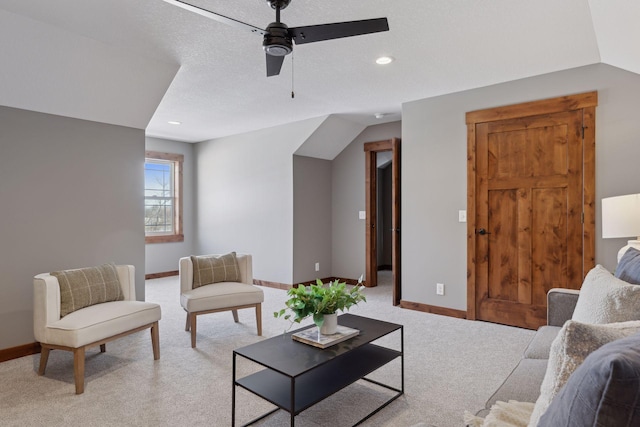 carpeted living room featuring ceiling fan and a textured ceiling