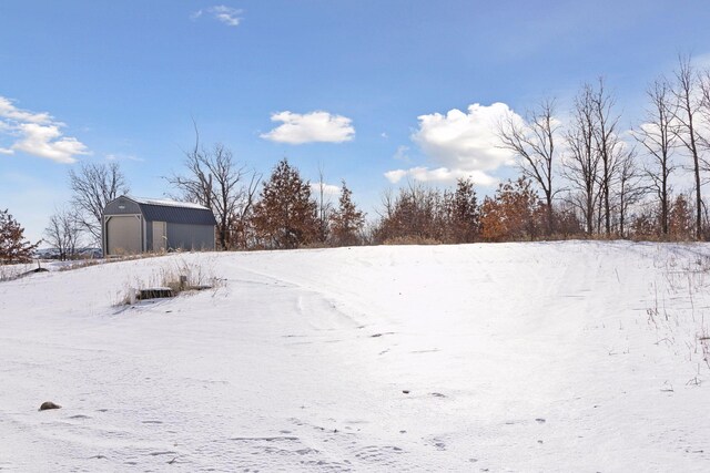 yard covered in snow featuring an outbuilding and a garage