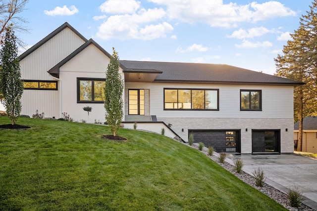 modern farmhouse featuring a front yard and a garage